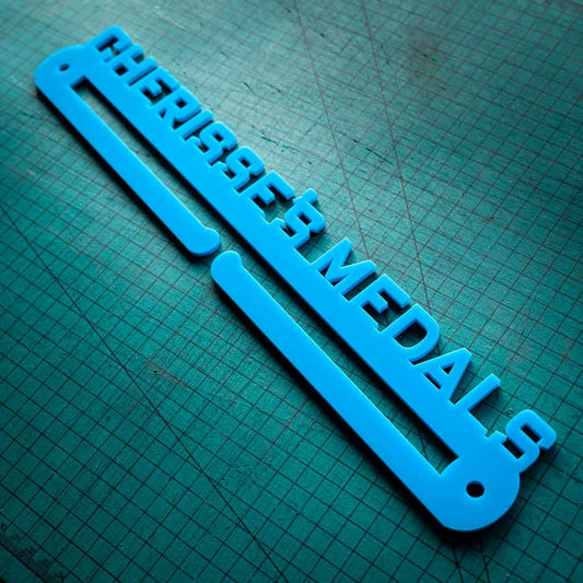 A personalise medal holder with the name of the person's medals