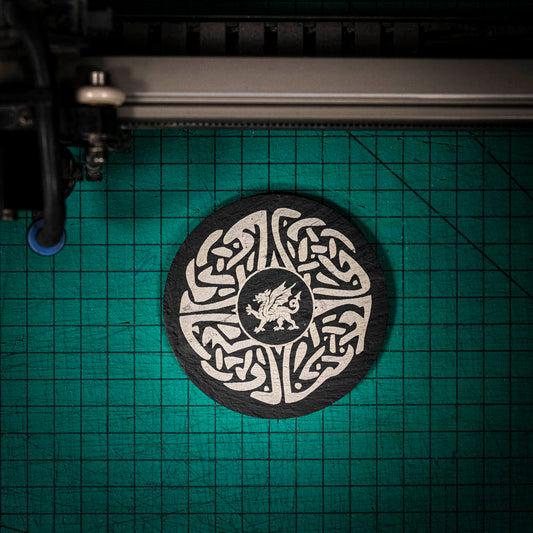 A laser engraved Welsh slate coaster with a welsh dragon in the center of a celtic knot