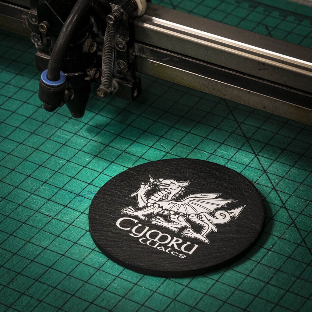 A laser engraved Welsh slate coaster with a welsh dragon and the words cymru and wales