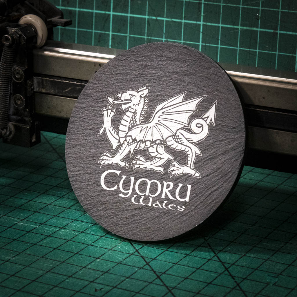 A laser engraved Welsh slate coaster with a welsh dragon and the words cymru and wales