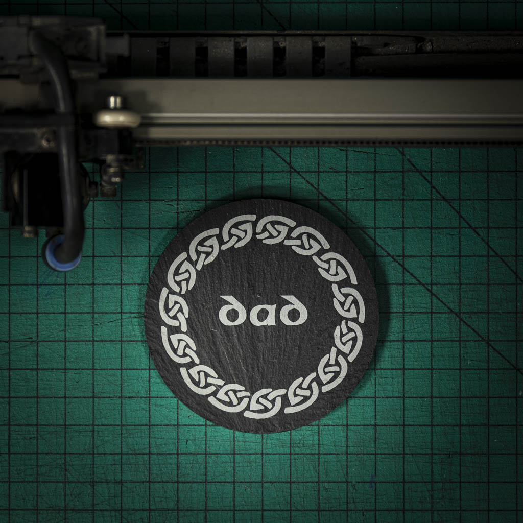 A Welsh slate coaster laser engraved with the word dad inside a celtic knot