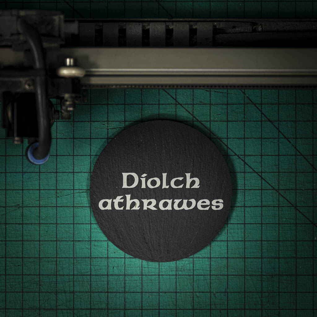 A Welsh slate coaster laser engraved with the welsh word for thank you teacher diolch athrawes