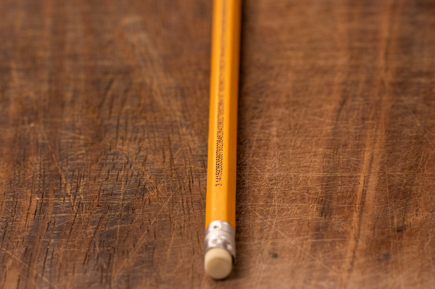 A yellow pencil that is engraved with the irrational number Pi up to 100 decimal places
