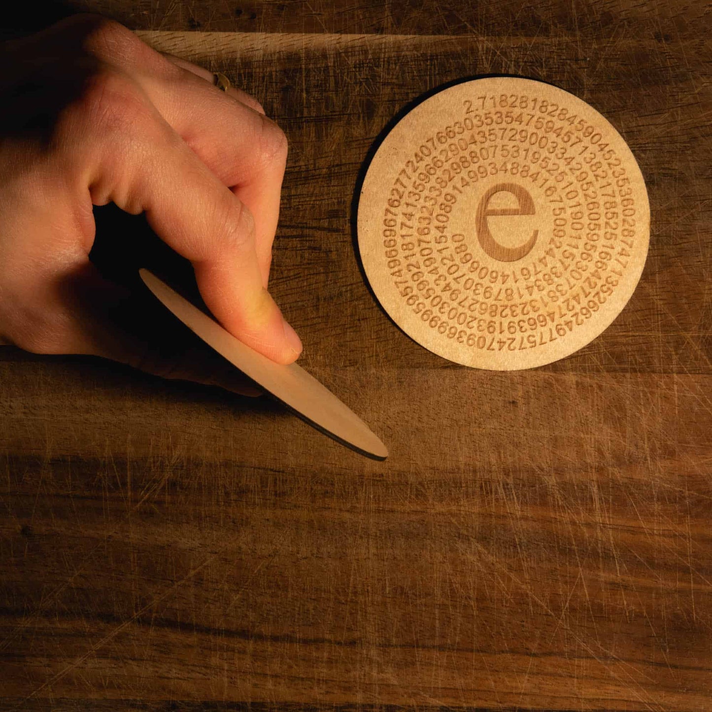 A laser engraved wooden coaster with Euler's number to 250 figures in a circle