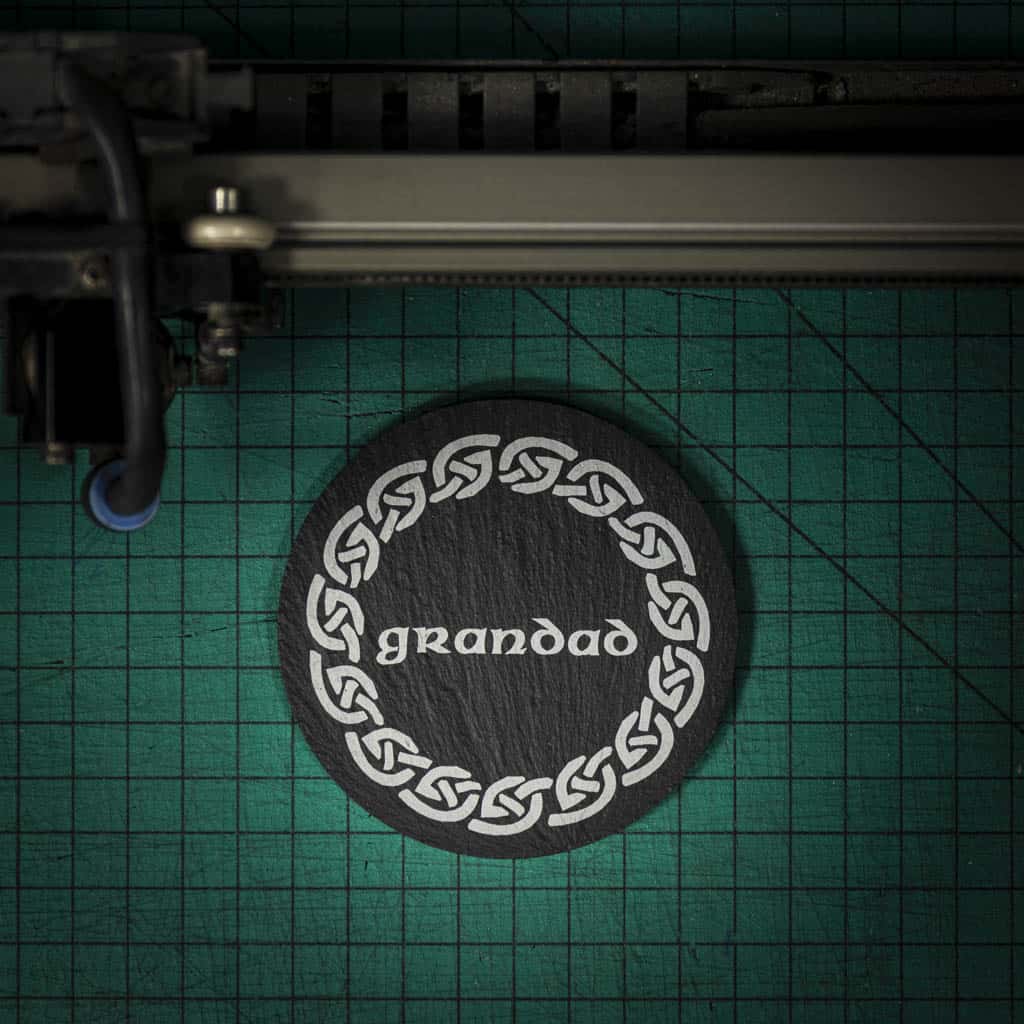 A Welsh slate coaster laser engraved with the word grandad inside a celtic knot