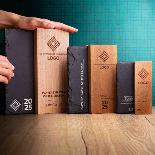 The Henge Award range, small, medium and large. A range of laser-engraved, eco-friendly wooden and slate trophies, made of two pieces of Sapele wood with a piece of natural Snowdonian slate with a hand holding them to give perspective of size.