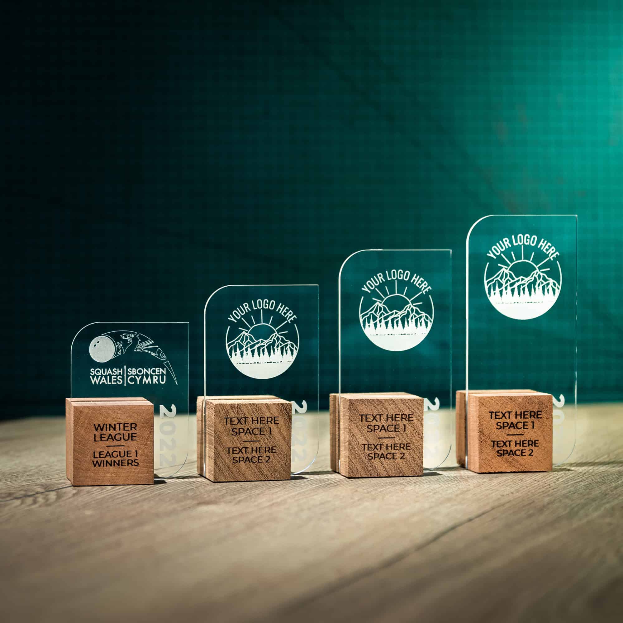 Four personalised laser engraved Perspex trophies with an eco friendly wooden base