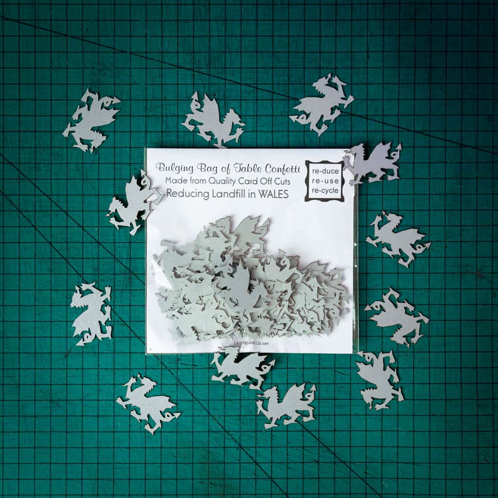A bag of silver dragon confetti laser cut from recycled card