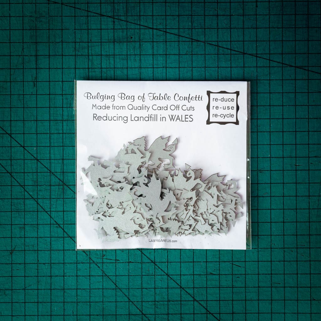 A bag of silver dragon confetti laser cut from recycled card