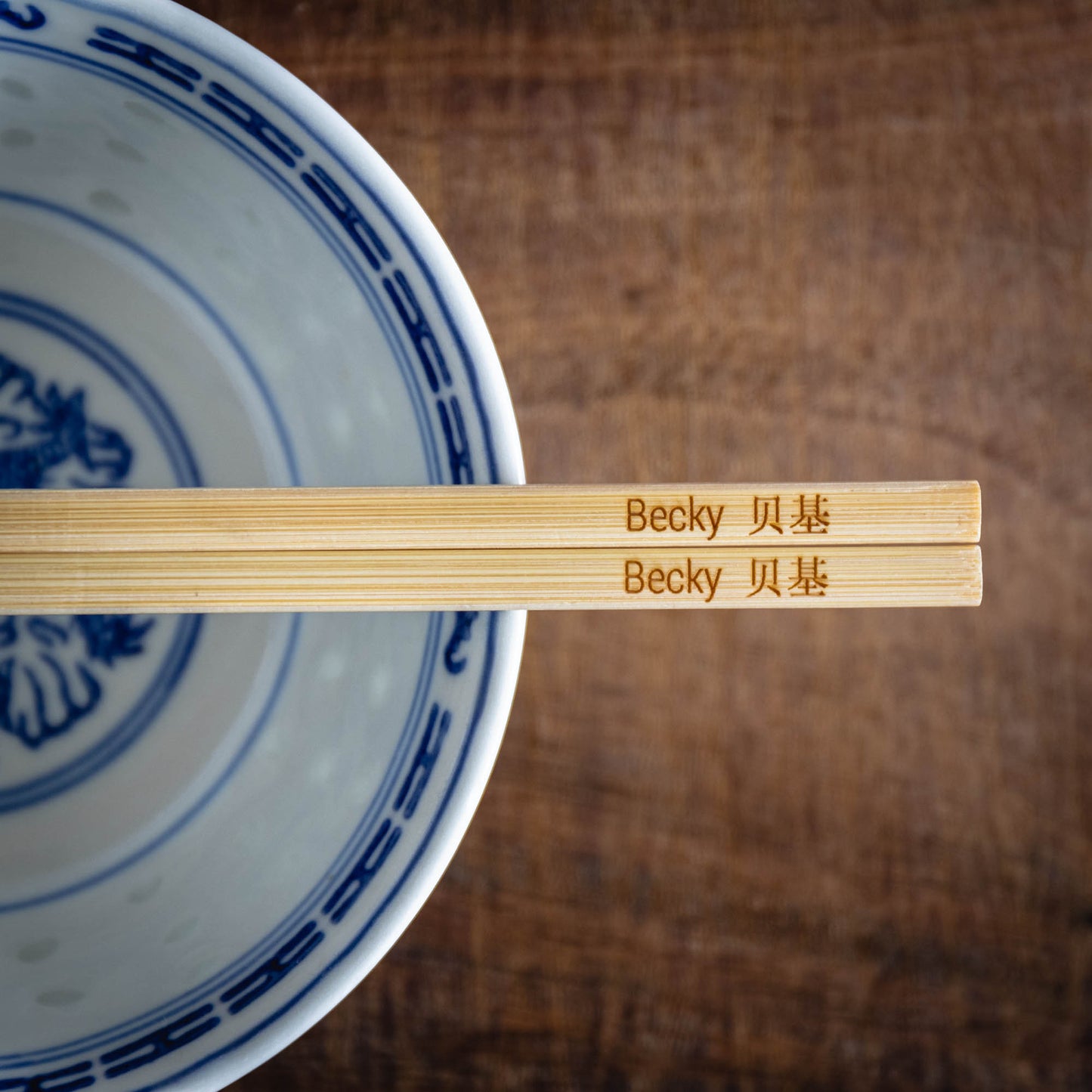 A personalised pair of bamboo chopsticks laser engraved with a name in English and Chinese