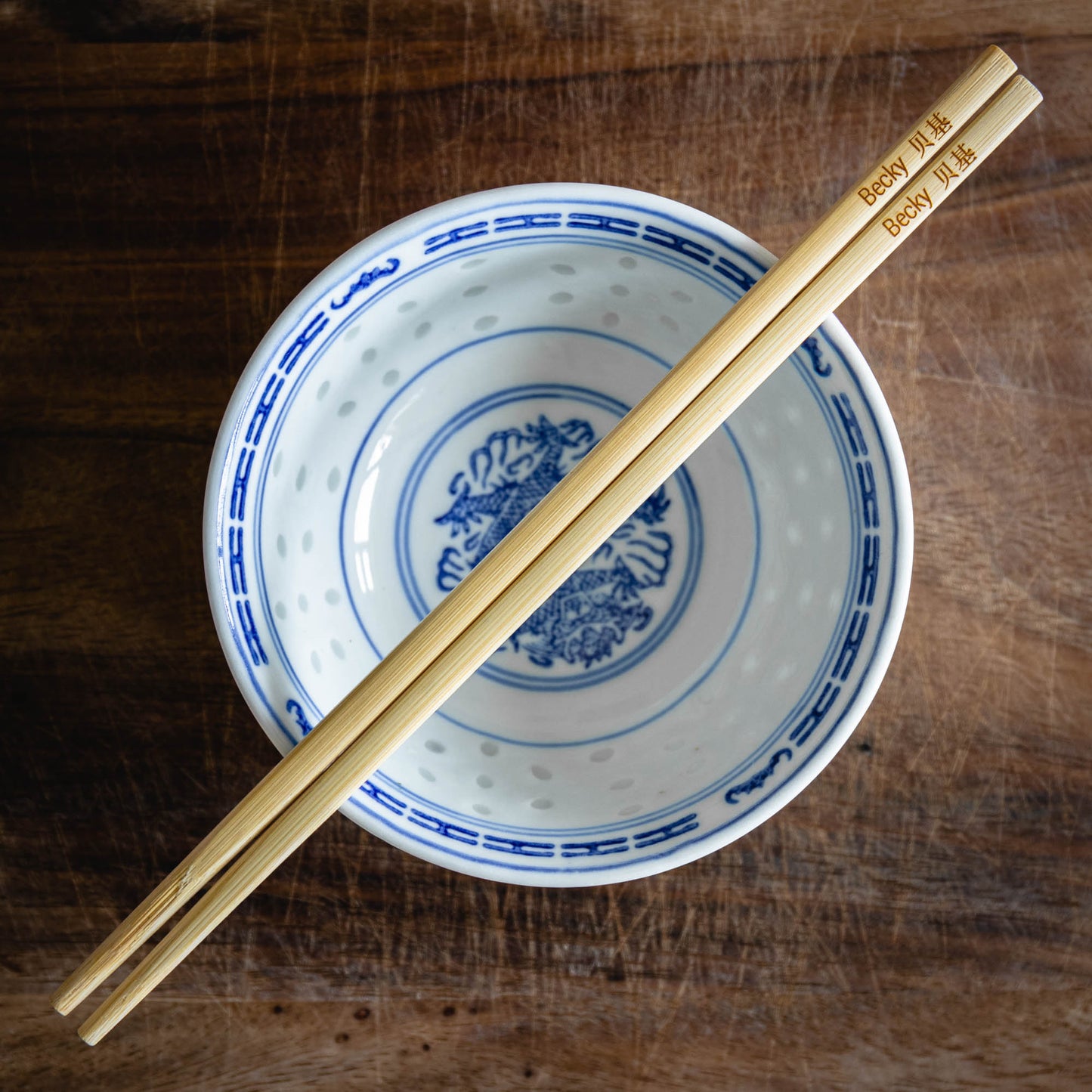 A personalised pair of bamboo chopsticks laser engraved with a name in English and Chinese