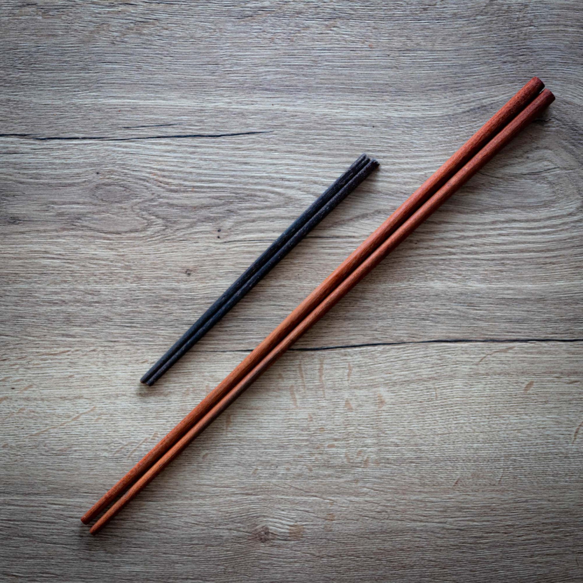 Long wooden cooking chopsticks next to a pair of normal chopsticks for comparison