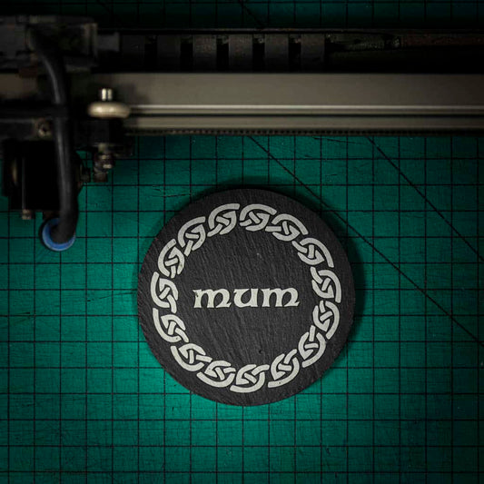 A Welsh slate coaster laser engraved with the word mum inside a celtic knot