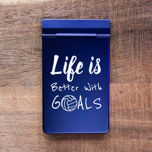 A notepad with a blue anodized metal cover with the phrase "Life is better with goals" laser marked onto the cover
