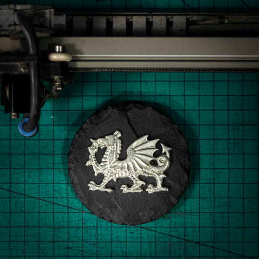 A Welsh slate paper weight with a pewter dragon