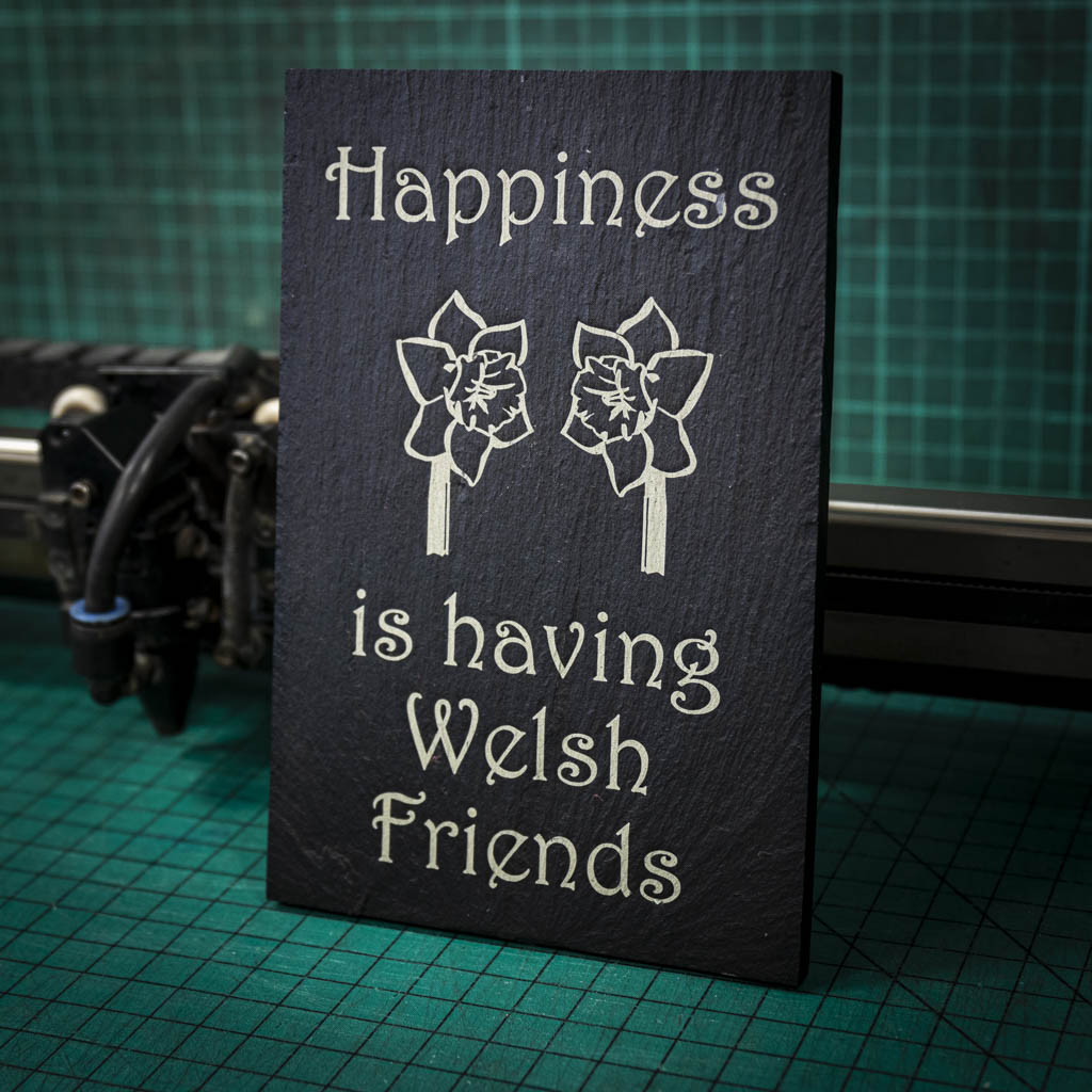 A welsh slate stand up plaque laser engraved with happiness is having welsh friends and two welsh daffodils