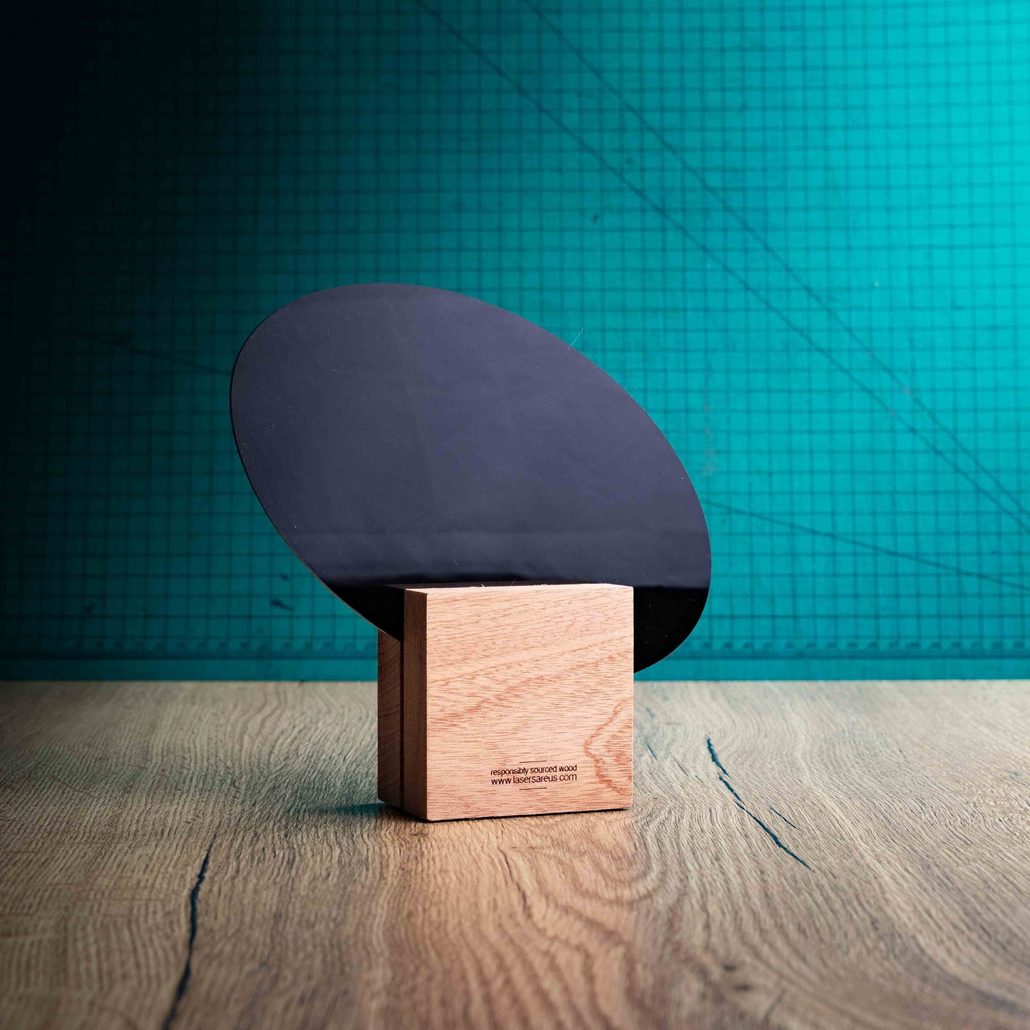 The back of the Rugby Award, an Eco-friendly wooden trophy with 'responsibly sourced wood' text and www.lasersareus.com on a wooden surface.