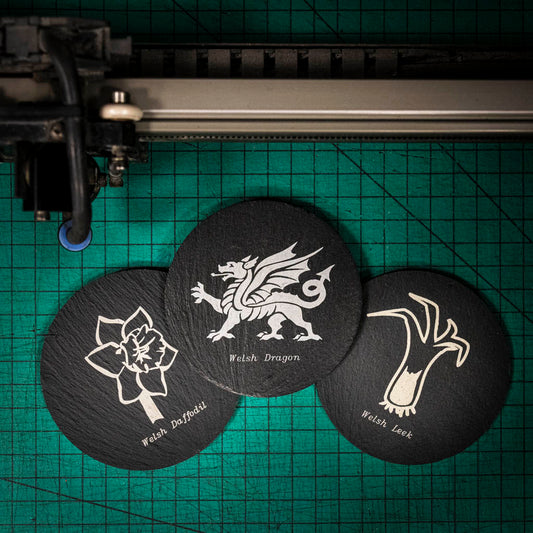 Three laser engraved Welsh slate coaster with the welsh emblems on, a dragon, a leek and a daffodil