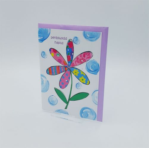 A welsh greetings card with a flower and the welsh word penblwydd hapus