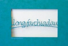 A laser cut card with the welsh word llongyfarchiadau