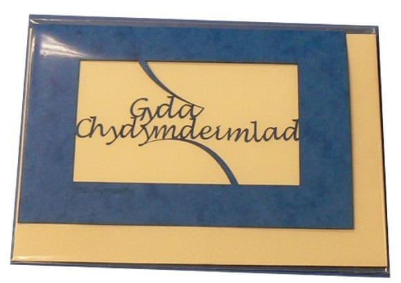 A laser cut card with the welsh word Gyda Chydymdeimlad