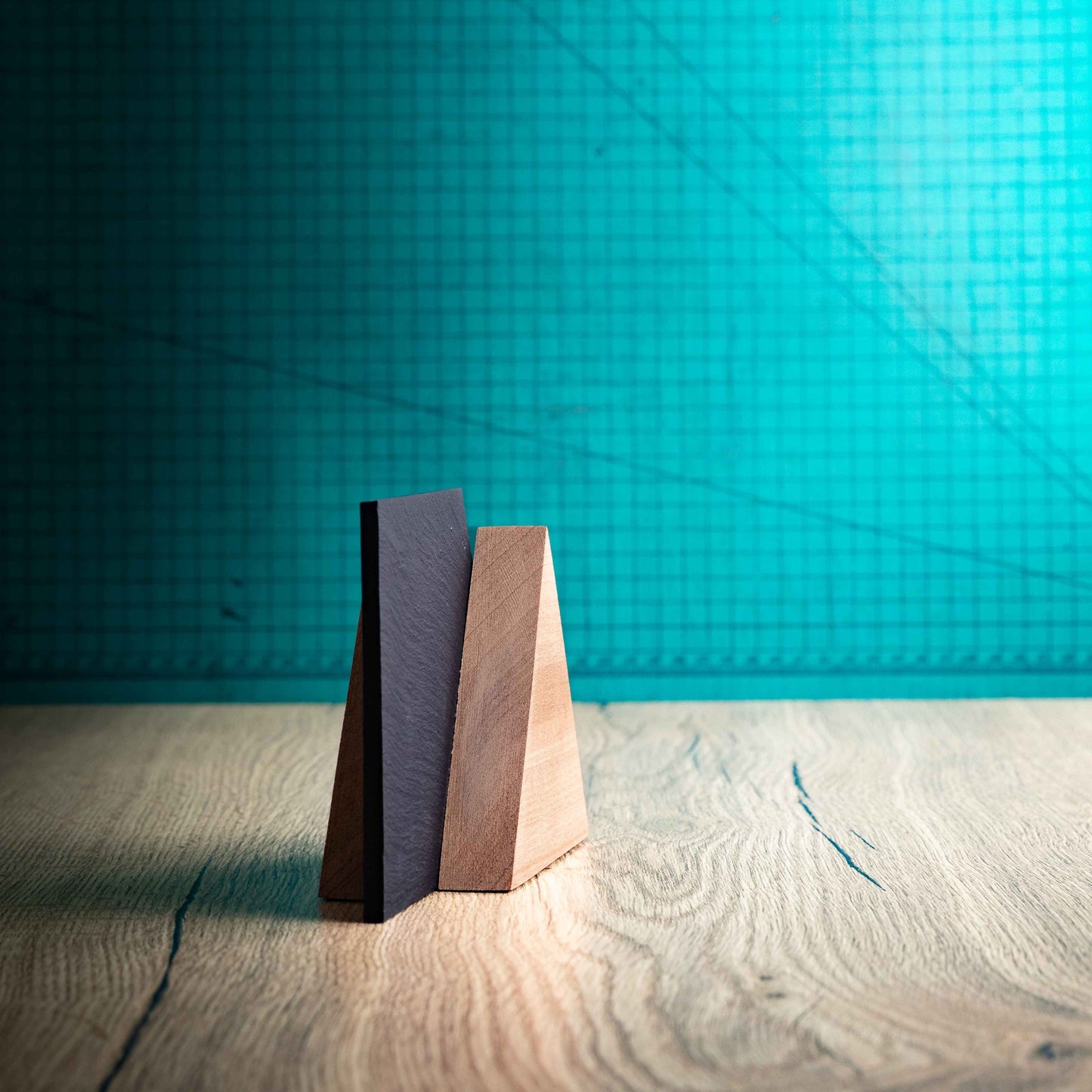 A side angle of the Alpine Award, a laser-engraved, eco-friendly, wooden and slate trophy. The Alpine trophy has two triangular wooden pieces on either side of a square piece of Welsh Slate. The trophy is personalised with Event information and a logo. 