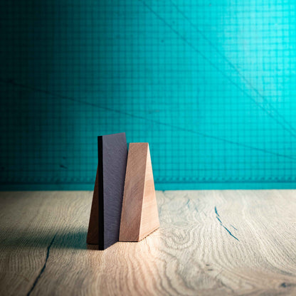 A side angle of the Alpine Award, a laser-engraved, eco-friendly, wooden and slate trophy. The Alpine trophy has two triangular wooden pieces on either side of a square piece of Welsh Slate. The trophy is personalised with Event information and a logo. 