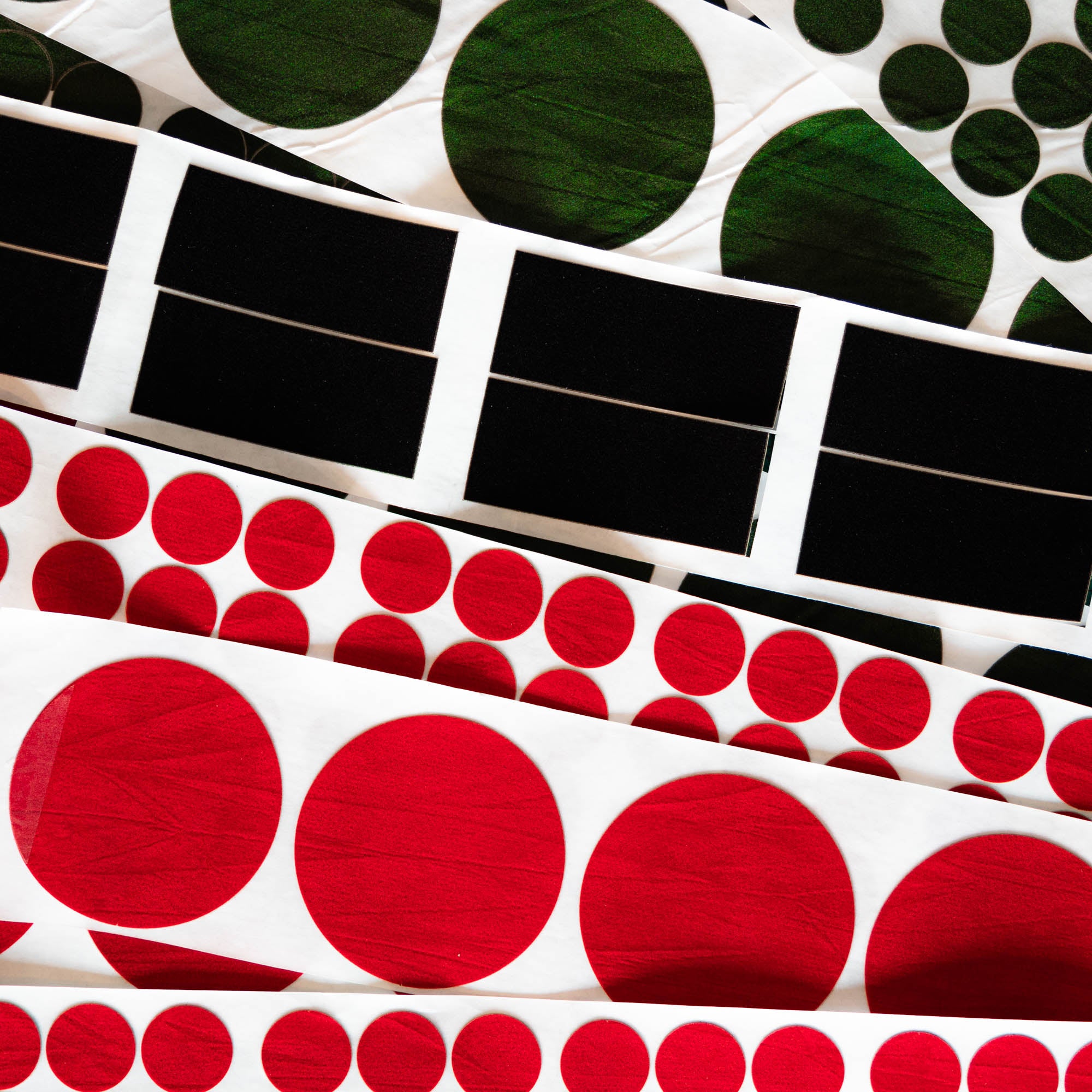 Collection of adhesive Baize in different shapes, sizes and colours, including circles and rectangles in red, green and black Baize.
