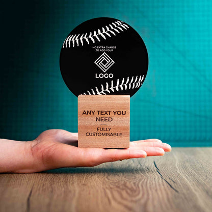 A medium Baseball trophy with custom text and logos, on an eco-friendly wooden base, with a black Perspex Baseball mounted on top, featuring fully customisable areas for text and logos, being held to show a size perspective.
