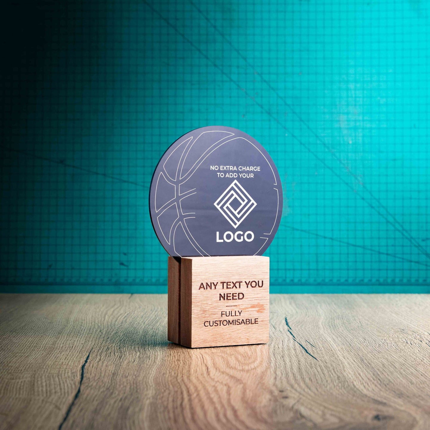 A side view of a medium Basketball trophy with custom text and logos, on an eco-friendly wooden base, with a black Perspex Basketball mounted on top, featuring fully customisable areas for text and logos.