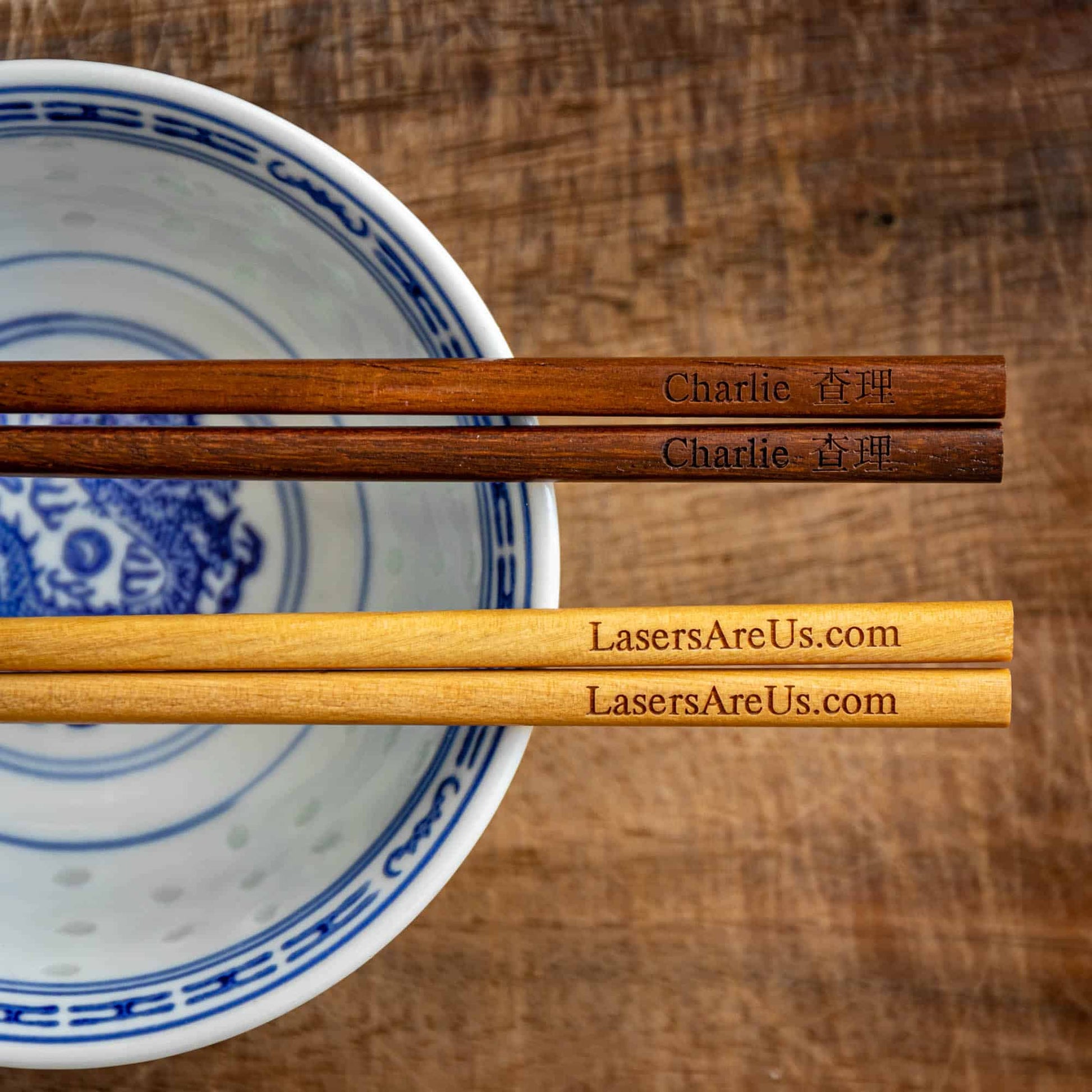 Two pairs of personalised Chinese Wooden Chopsticks, one dark wood, one light wood, personalised with a name translated into Chinese and a Company Logo