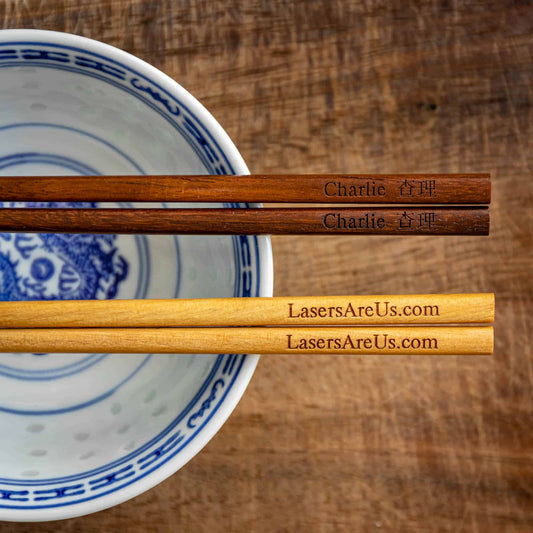 Two pairs of personalised Chinese Wooden Chopsticks, one dark wood, one light wood, personalised with a name translated into Chinese and a Company Logo