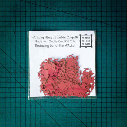 A bag of red dragon confetti laser cut from recycled card