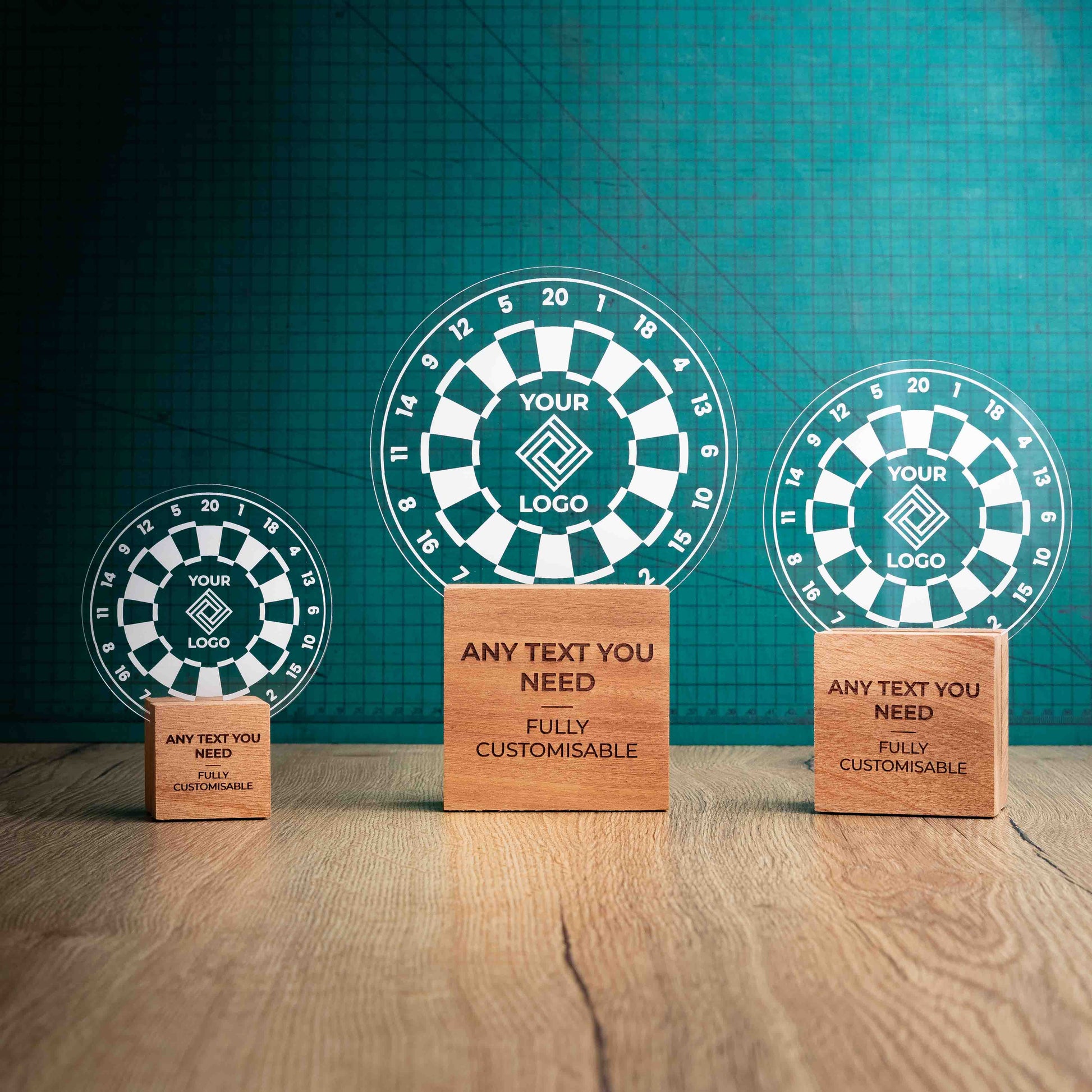 Three darts trophies with custom text and logos, on eco-friendly wooden bases, with a clear Perspex darts board mounted on top, featuring fully customisable areas for text and logos.