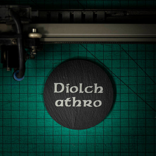 A Welsh slate coaster laser engraved with the welsh word for thank you teacher diolch athro