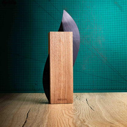 The back of the Flame Award, an Eco-friendly wooden trophy with 'responsibly sourced wood' text and www.lasersareus.com on a wooden surface.