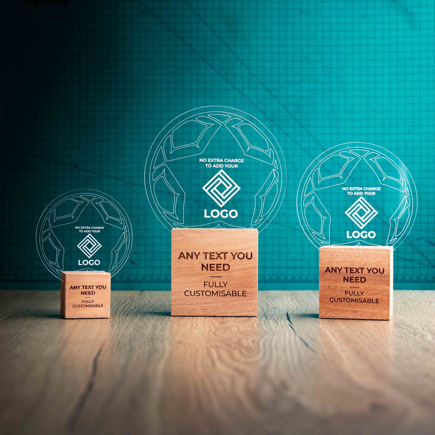 Three football trophies with custom text and logos, on eco-friendly wooden bases, with a clear Perspex football mounted on top, featuring fully customisable areas for text and logos