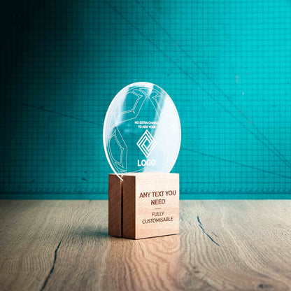 A side view of a medium football trophy with custom text and logos, on an eco-friendly wooden base, with a clear Perspex football mounted on top, featuring fully customisable areas for text and logos.