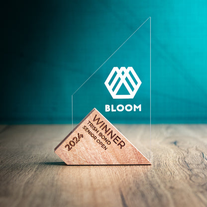 A Large Genoa Award. An Eco-Friendly Wooden and Perspex Award that has a wooden base engraved with a logo and a recyclable clear Perspex triangular shape with a point on the left side of the trophy, which contains the winner and event information.