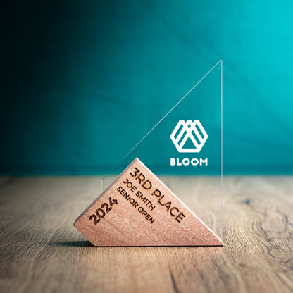 A Small Genoa Award. An Eco-Friendly Wooden and Perspex Award that has a wooden base engraved with a logo and a recyclable clear Perspex triangular shape with a point on the left side of the trophy, which contains the winner and event information.
