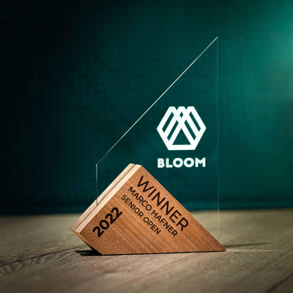 A Large Genoa Award. An Eco-Friendly Wooden and Perspex Award that has a wooden base engraved with a logo and a recyclable clear Perspex triangular shape with a point on the left side of the trophy, which contains the winner and event information.