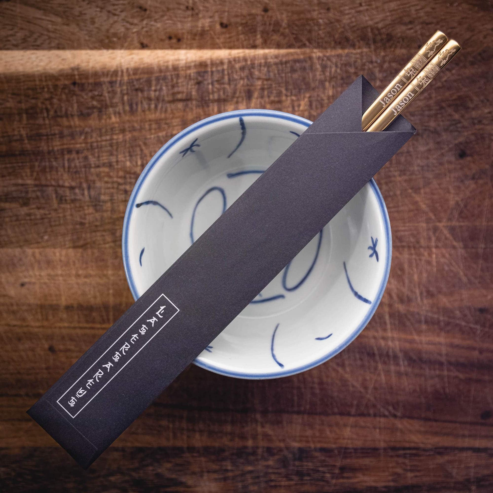 A pair of personalised Gold Chinese Zodiac Chopsticks, Rabbit, laser engraved with a name of your choice, in a black paper pouch
