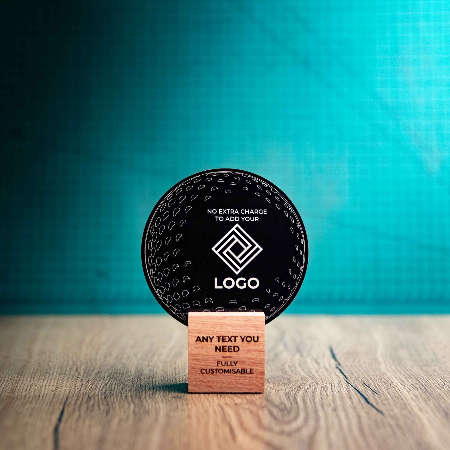 A small golf award trophy with custom text and logos, on an eco-friendly wooden base, with a black Perspex golf ball mounted on top, with fully customisable areas featuring fully customisable areas for text and logos.