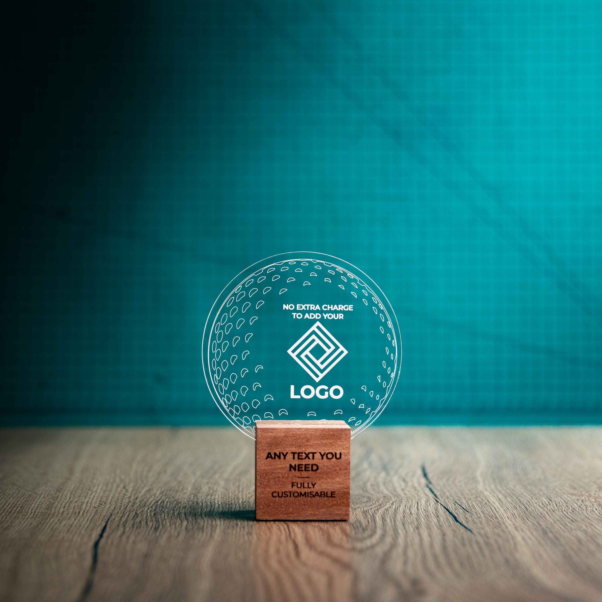 A small golf award trophy with custom text and logos, on an eco-friendly wooden base, with a clear Perspex golf ball mounted on top, with fully customisable areas featuring fully customisable areas for text and logos.