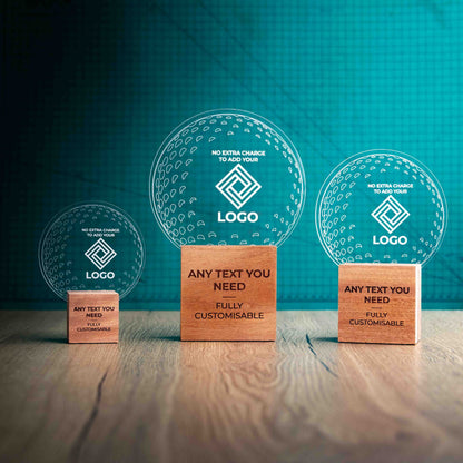 Three golf award trophies with custom text and logos, on eco-friendly wooden bases, with a clear Perspex golf ball mounted on top, with fully customisable areas featuring fully customisable areas for text and logos.