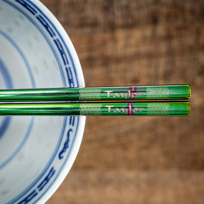 A pair of Chinese-style Metal Coloured Chopsticks - Iridencence. Each pair is personalised with either a name or a phrase.