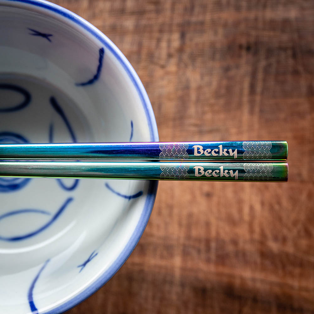 A pair of Chinese-style Metal Coloured Chopsticks - Iridencence. Each pair is personalised with either a name or a phrase.