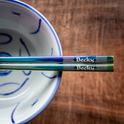 A pair of Chinese-style Metal Coloured Chopsticks - Iridencence. Each pair is personalised with either a name or a phrase.