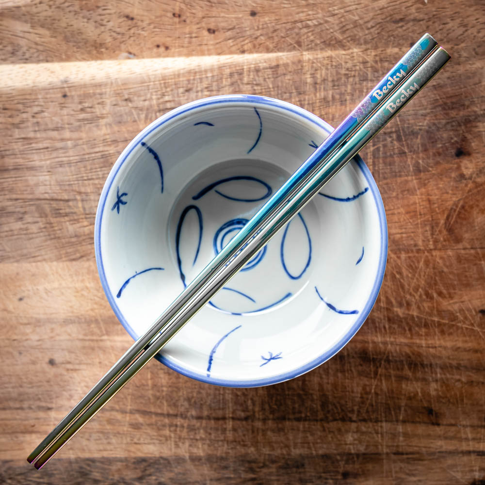 A pair of Chinese-style Metal Coloured Chopsticks - Iridencence. Each pair is personalised with either a name or a phrase.