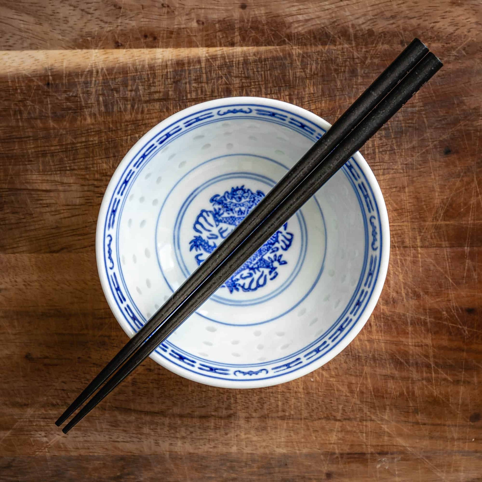 A pair of Japanese-style Chopsticks, Black wood. The pair is personalised with either a name or a phrase in English, translated into either Chinese or Japanese, and features a contemporary design at the end of the chopsticks.